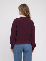 MAZINE burgundy chunky knit V-neck pullover sweater on a model, showing its cozy, textured knit fabric and relaxed fit.