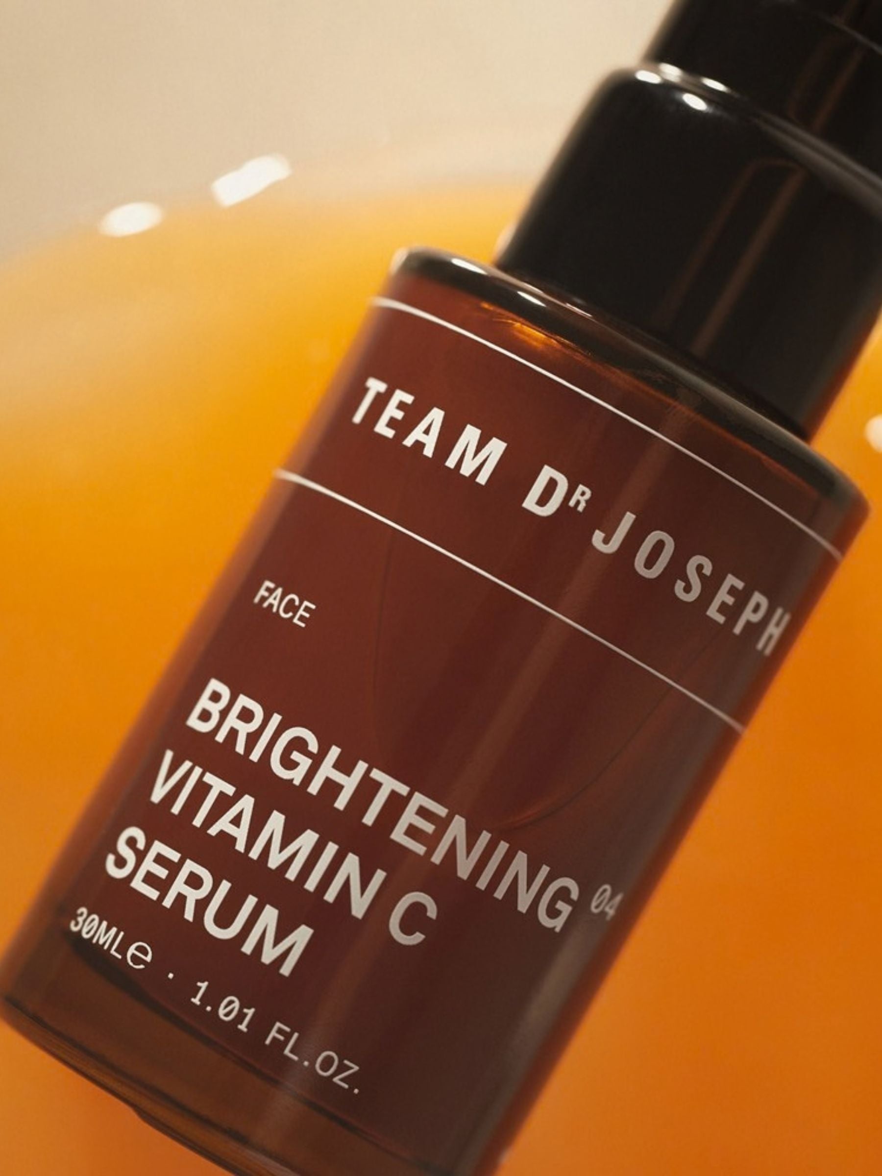 Dropper bottle of TEAM DR JOSEPH Brightening Vitamin C Serum 30 ml, with a clear liquid and white label on a white background.