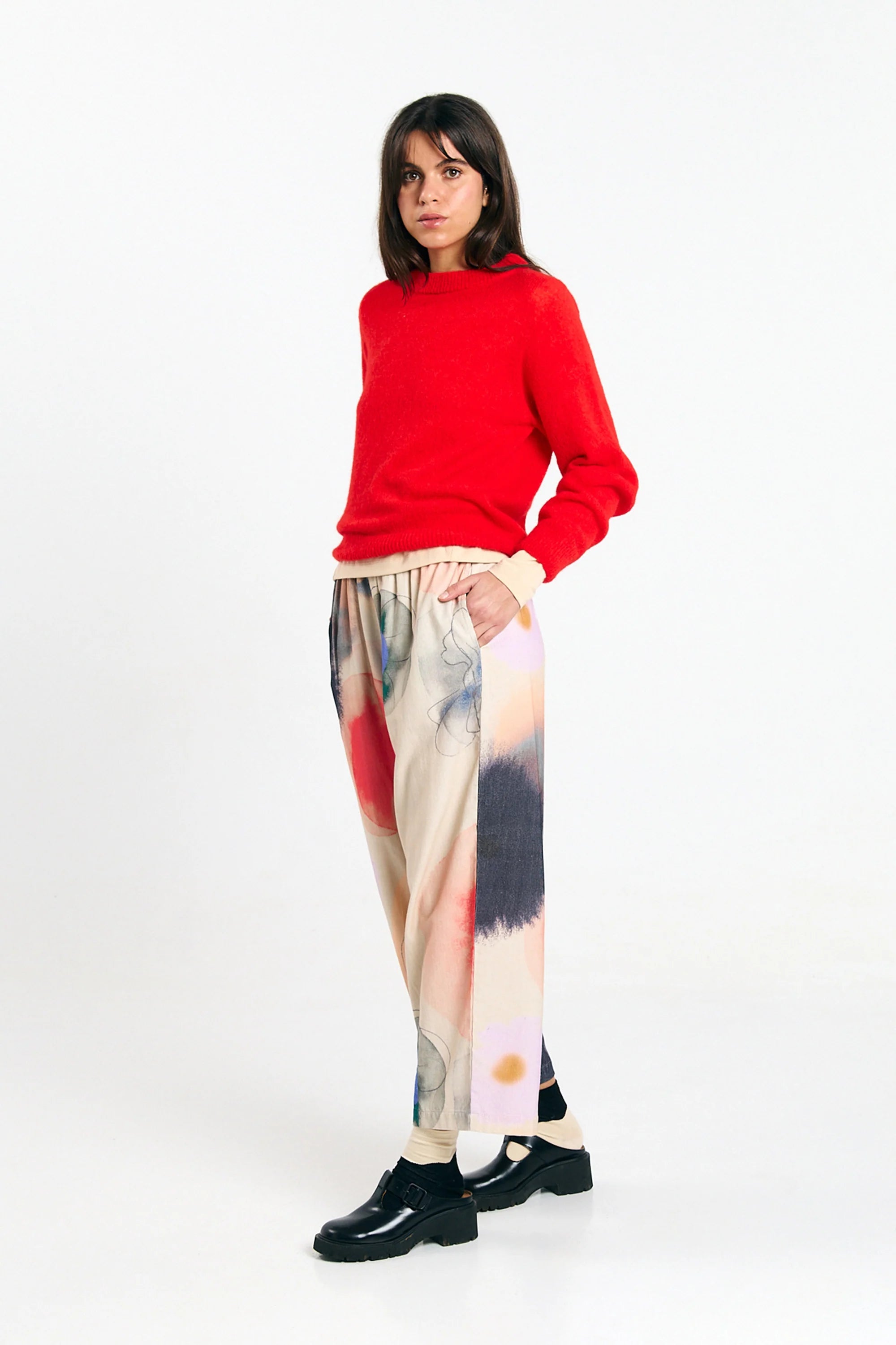 Red Babol Jumper sweater by SUITE13LAB displayed on a hanger with a cozy knit texture and ribbed cuffs.