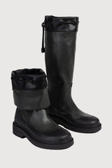 Pair of black knee-high boots on a light gray background