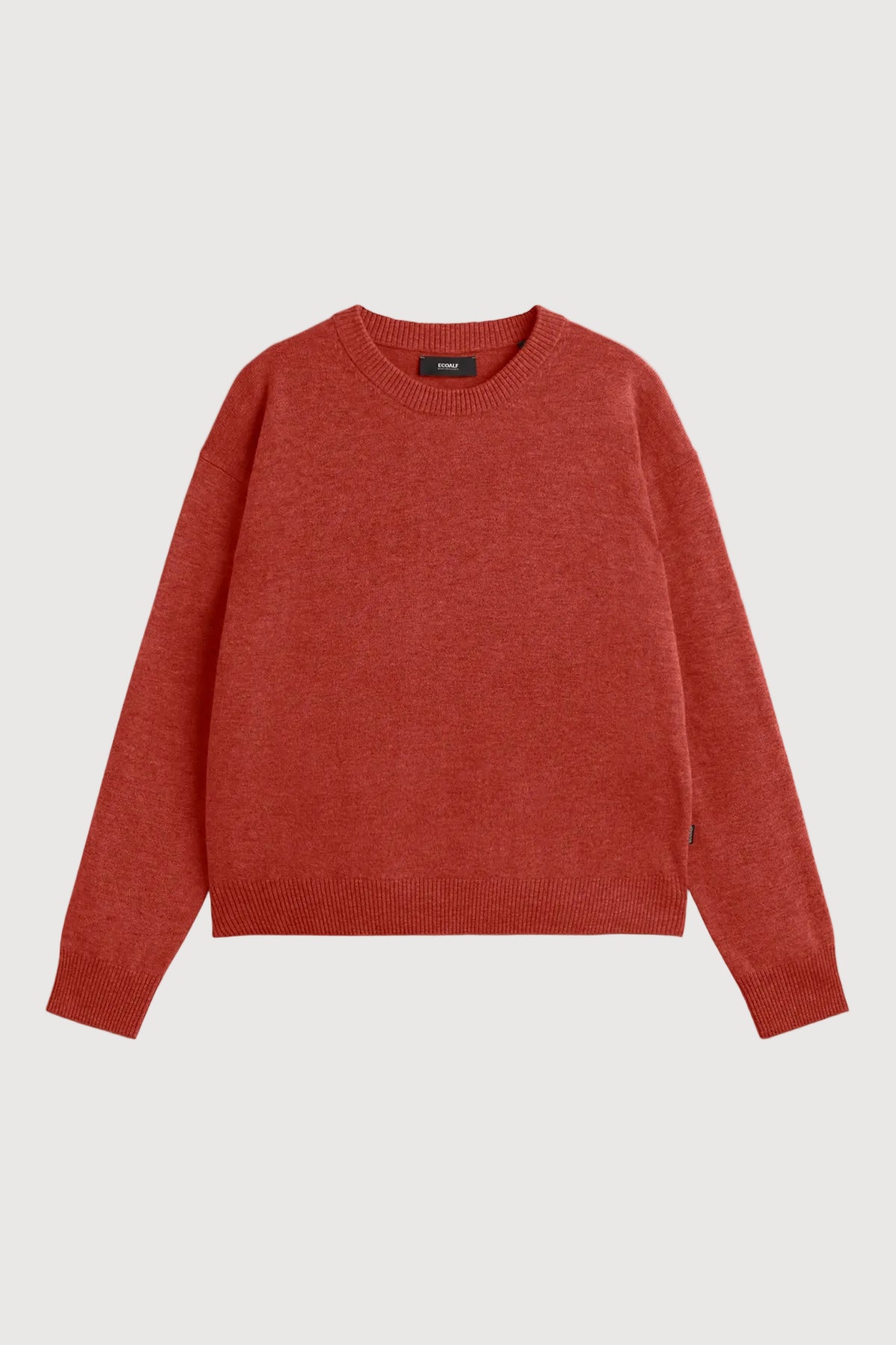 A rust-red crewneck knit sweater with long sleeves, laid flat against a light gray background.