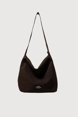 A dark brown ribbed slouchy shoulder bag with a single strap, shown against a light gray background.
